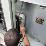 Two hands holding copper pipe fittings
