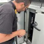 Open equipment cabinet showing a blower wheel and motor