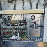 Wall-mounted control panel with a digital display and indicator lights