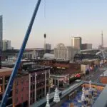 Mobile crane lifting a rooftop unit onto a building