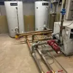 Two green cylindrical boilers side by side